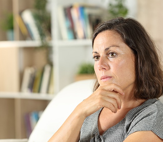 Woman sitting on couch looking concerned